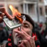 A protester burns fake US dollars during a pro-Iranian regime demonstration in front of the Iranian consulate in Istanbul, on January 18, 2026.
