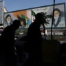 People walk past a mural depicting the late leader of the Islamic Revolution, Ayatollah Ruhollah Khomeini, and Iran's late Supreme Leader Ayatollah Ali Khamenei, in Tehran, Iran, May 25, 2026.