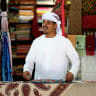A vendor organises textiles at a shop in Central Souq on July 22, 2015 in Sharjah, United Arab Emirates.