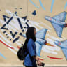 An Iranian woman walks next to an anti-Israeli mural on a street in Tehran, Iran, May 26, 2026.