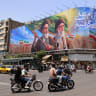 People ride motorcycles past a large billboard showing portraits of Iran's late supreme leader, Ayatollah Ruhollah Khomeini (L) and slain supreme leader Ayatollah Ali Khamenei (R) in central Tehran on June 8, 2026. 