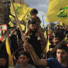 Supporters of Lebanon's Hezbollah wave flags while commemorating Israel’s withdrawal from southern Lebanon in 2000, in the southern suburbs of Beirut, Lebanon, May 25, 2026. 