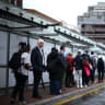 Commuters queue for a red double decker bus outside Victoria train station, in south west London on June 2, 2026.