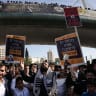 Ultra-Orthodox Jews hold placards during a protest against conscription in Israel's military, in Jerusalem on October 30, 2025.