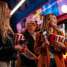A group of diverse people are queueing up in a movie theater to watch a movie.