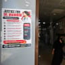 A woman walks past a poster displayed by medical practitioners to express solidarity with acid attack victim doctor Mahnoor Nasir, at a hospital in Quetta on June 9, 2026.