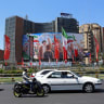 Iranians drive past a huge billboard carrying the image of the late Iranian supreme leader, Ayatollah Ali Khamenei, on a street in Tehran. Iranians remain defiant despite US and Israeli pressure. 