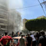 People gather at the site of an Israeli airstrike that targeted a building in Beirut's southern suburbs on June 14, 2026. 