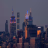 The Empire State Building, JPMorgan Chase Building, and One Vanderbilt in New York City are illuminated in the colors of the New York Knicks during Game 5 of the NBA Finals on June 13, 2026, as seen from Bayonne, New Jersey.  