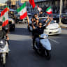 Youths ride vehicles while waving flags of Iraq, Iran, Lebanon and Hezbollah in Baghdad on June 15, 2026, during celebrations following the announcement of a deal to end the war between Iran and the US. 