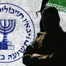Imagen ilustrativa de un agente del Mossad de pie frente a unas banderas con el lema «Mossad contra Irán» colocadas en una pared agrietada.