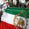 Un manifestante contrario al régimen iraní sostiene una bandera iraní anterior a la revolución de 1979, con el emblema del León y el Sol, durante una protesta frente a la embajada de Irán en el centro de Londres, el 20 de marzo de 2026. 