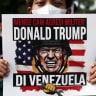Un activista sostiene una pancarta en la que se lee «Condenamos la agresión militar de Donald Trump en Venezuela», durante una manifestación contra Estados Unidos, tras el ataque estadounidense a Venezuela y la captura de su presidente, Nicolás Maduro, y su esposa, Cilia Flores frente a la embajada