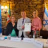 Dr. Luis Andrade, president of the ODIH, presenting the commemoration tribute to two members of the Porto Jewish Community, Dara Jeffreys (Left) and Liat Cohen (right).