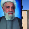 A poster of Lebanese Shiite movement Hezbollah's leader Naim Qassem (L) is displayed near another of the group's late leader Hassan Nasrallah outside shelters at the Imam Ali Housing Compound, where displaced Lebanese and Syrian refugee Shiite Muslims take refuge by the city of Hermel in Lebanon.