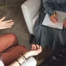 A THERAPIST speaks with a patient.
