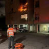 A Unit Hatzalah medic stands in front of a burning apartment building on Macdonald Street in Netanya, 18 June, 2026.