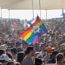 A participant waves an Israeli flag and a rainbow flag with a Star of David above a crowd during the annual Pride Parade in Tel Aviv, Israel, on June 12, 2026.