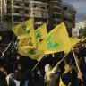 Varias personas sostienen banderas de Hezbolá mientras conmemoran la retirada de Israel del sur del Líbano en 2000, en los barrios del sur de Beirut, Líbano, el 25 de mayo de 2026. 