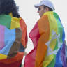 Participants draped in pride flags, featuring a Star of David, stand together during the annual Pride Parade in Tel Aviv, Israel, on June 12, 2026.