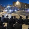 Ultra-Orthodox Jewish men block the light rail tracks during a protest against the jailing of seminary students who failed to comply with an army recruitment order outside Old City of Jerusalem, April 28, 2026.