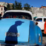 A man casts his shadow on a vintage taxi before the Cuban government presents far-reaching economic measures that could mark the most significant shift toward a market economy since the 1959 revolution, in Havana, Cuba June 17, 2026.
