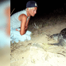 Mona Khalil, a Lebanese ecologist activist looks at a turtle at a coast in the southern Lebanese port city of Tyre, August 12, 2002; file photo.