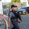 An armed policeman walks past the main gate of the Senate during a lockdown at the Senate premises in Manila on May 11, 2026 as NBI agents try to serve an International Criminal Court (ICC) arrest warrant on former Philippines national police chief and now sitting Senator Ronald Dela Rosa. 