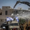 ISRAELI SECURITY forces guard while Israeli bulldozers demolish a Palestinian home in the Khirbet Qalqas area, south of the city of Hebron in the West Bank, June 23, 2026.