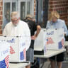 People fill out ballots as a poll worker makes a phone call on Election Day for the midterm primary on June 9, 2026 at Dreher High School in Columbia, South Carolina. 