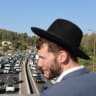 A haredi (ultra-Orthodox) man looks on as protesters form a convoy blocking Highway 1 west of Jerusalem, June 24, 2026; illustrative.