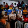 People gather as emergency services work at the site of a collapsed building after earthquakes hit the country, in Caracas, Venezuela, June 25, 2026. 