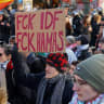 A protester displays a placard with a slogan against the Israel Defense Forces (IDF) and Hamas during a pro-Palestinian demonstration in Leipzig, Germany January 17, 2026