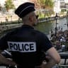Police watch as people swim in the Canal Saint-Martin after public swimming was permitted in certain areas due to high temperatures amid a heatwave in Paris, France, June 26, 2026.