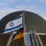 Flags flutter in front of a radom of the "Arrow Weapon System for Germany" pictured in Annaburg, Germany, December 3, 2025. 