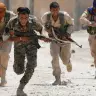 Combatientes kurdos de las Unidades de Protección Popular (YPG) cruzan corriendo una calle en Raqqa, Siria, el 3 de julio de 2017. 