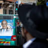People walk past election posters for the upcoming elections in Jerusalem on October 24, 2022.