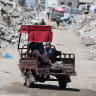 Palestinians ride past the rubble of residential buildings destroyed during the Israeli offensive, in Gaza City, June 23, 2026.