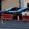 A woman walks her dogs as Orange County sheriff's deputies block Western Avenue after a chemical leak from a large storage tank prompted evacuations in Garden Grove, California, on May 24, 2026. 