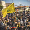 A boy holds a yellow Hezbollah flag while walking among a crowd during a mourning ceremony in the southern suburbs of Beirut, Lebanon, June 26, 2026