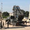 Israeli soldiers walk near an Israeli Irone Dome defence system (L), a surface-to-air missile (SAM) system, the MIM-104 Patriot (C), and an anti-ballistic missile the Arrow 3 (R) during Juniper Cobra's joint exercise press briefing at Hatzor Israeli Air Force Basel, on February 25, 2026.