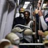 A passenger looks on as members of the white supremacist group Patriot Front ride the Washington Metro on July 04, 2026 in Washington, DC. 