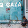 A boy sits outside the entrance to an UNRWA building complex in Gaza City.