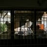 Media personnel are seen through a damaged glass window at a prison facility in the Malir district of Karachi on June 3, 2025.