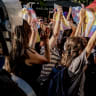 Protesters hold up Pride flags as they stand in front of riot police officers in Izmir, Turkey, on June 27, 2026.