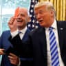 US President Donald Trump holds up a red card as he meets with FIFA President Gianni Infantino in the Oval Office of the White House in Washington, August 2018; illustrative.