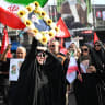 A woman reacts while holding a portrait of Iran's slain Supreme Leader Ali Khamenei as they gather and wait for his funeral procession at Ferdowsi Square in Tehran July 6, 2026. 