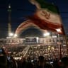 Mourners wave a national flag as the gather to pay tribute to Iran's slain supreme leader Ayatollah Ali Khamenei at the Grand Mosalla on the second day of funeral ceremonies in Tehran on July 5, 2026. 