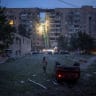 A flipped-over car lies near an apartment building, which was heavily damaged during Russian missile and drone strikes, amid Russia's attack on Ukraine, in Kyiv, Ukraine July 6, 2026.