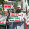 Muslim protesters hold placards as they shout slogans demanding the hanging of terrorist Hafiz Saeed in Mumbai on February 14, 2020.